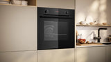 Modern kitchen with a black oven and light-colored cabinets